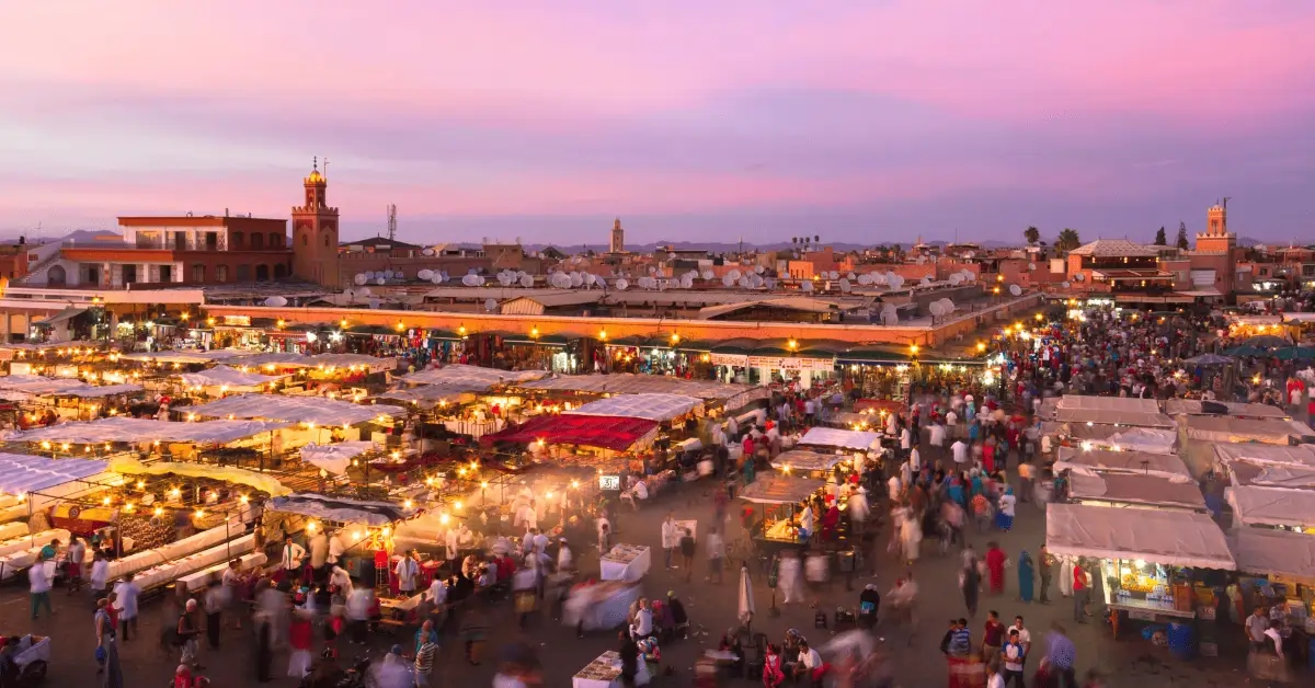 Morocco Itinerary 12 Days 26 Nighttime view of Jemaa el-Fnaa square in Marrakesh with lively crowds, street performers, and illuminated market stalls.