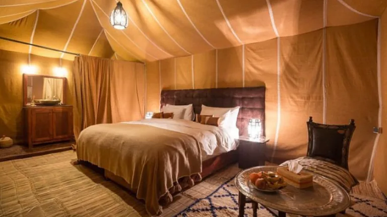 8 Days Fes to Marrakech Desert Tour 4 Luxury desert camp tent interior with a king-sized bed and modern amenities featured in a Morocco 8 day itinerary