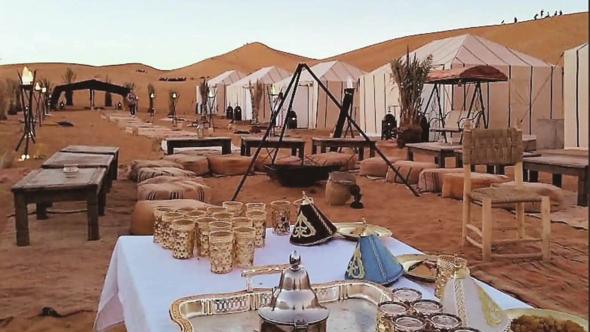 Luxury desert camp in Merzouga, Morocco, set among the Erg Chebbi dunes with traditional tents and serene desert views.