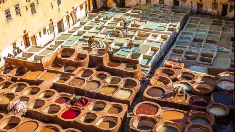 8 Days Fes to Marrakech Desert Tour 3 Traditional open-air leather vats filled with natural dyes in a historic medina setting.