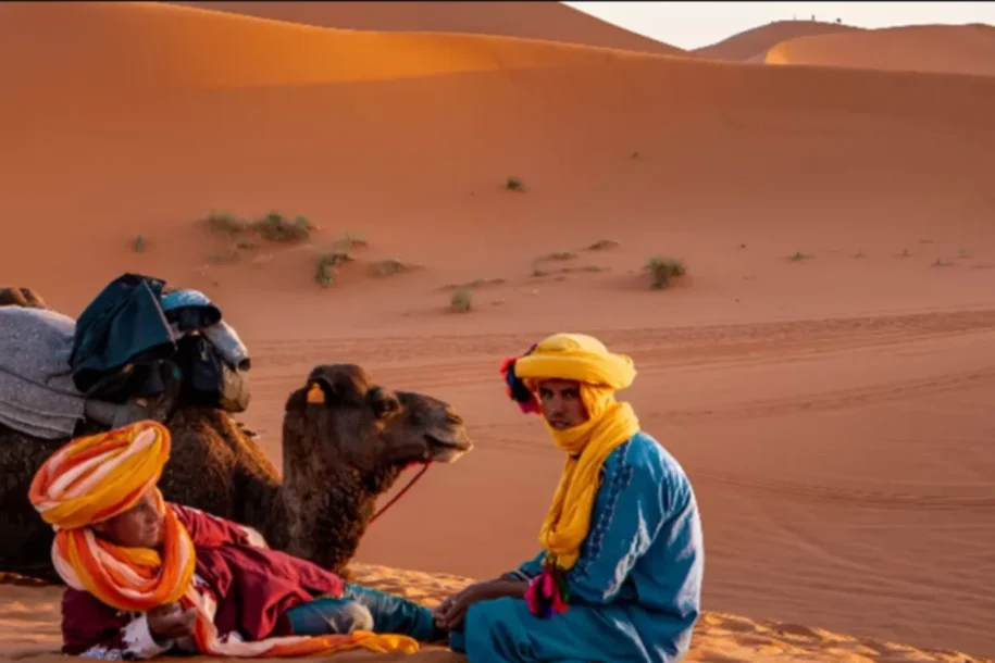 Berber guide and camel cross Erg Chebbi dunes, Merzouga; Morocco Weird Facts: sand sings, stars blaze, Sahara dreams begin.