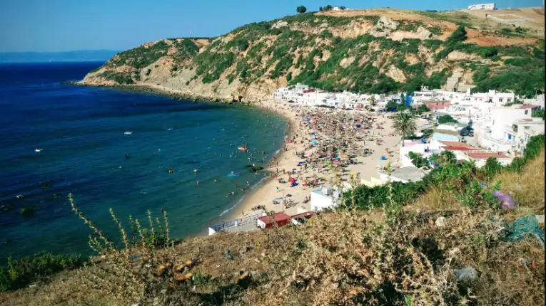 Best Beaches in Tangier (2026): Ultimate Guide for Travelers 6 A lively summer day at Playa Blanca near Tangier, featuring white sandy shores, calm waters, and beachgoers enjoying the seaside.