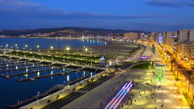 Best Beaches in Tangier (2026): Ultimate Guide for Travelers 3 Tangier Marina Bay at dusk along the municipal beach, featuring a lively waterfront promenade, glowing lights, and modern coastal atmosphere.