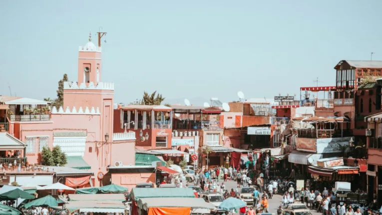 Jemaa el-Fnaa square in Marrakech with bustling market stalls, traditional architecture, and vibrant cultural atmosphere by morocco fun tours