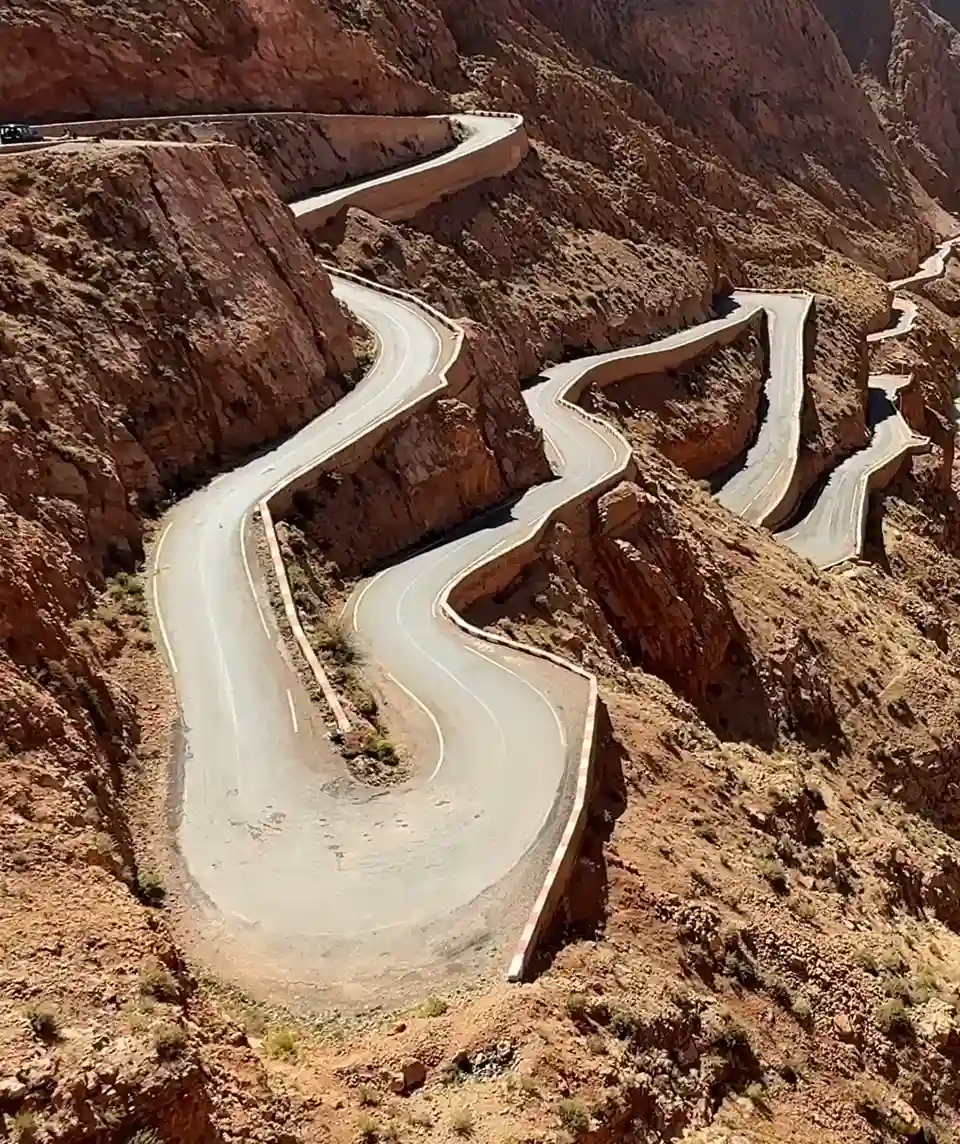 Home 6 Dades Gorge hairpin road winding through red rock cliffs, showcasing dramatic scenery experienced on Morocco Tours with Morocco Fun Tours